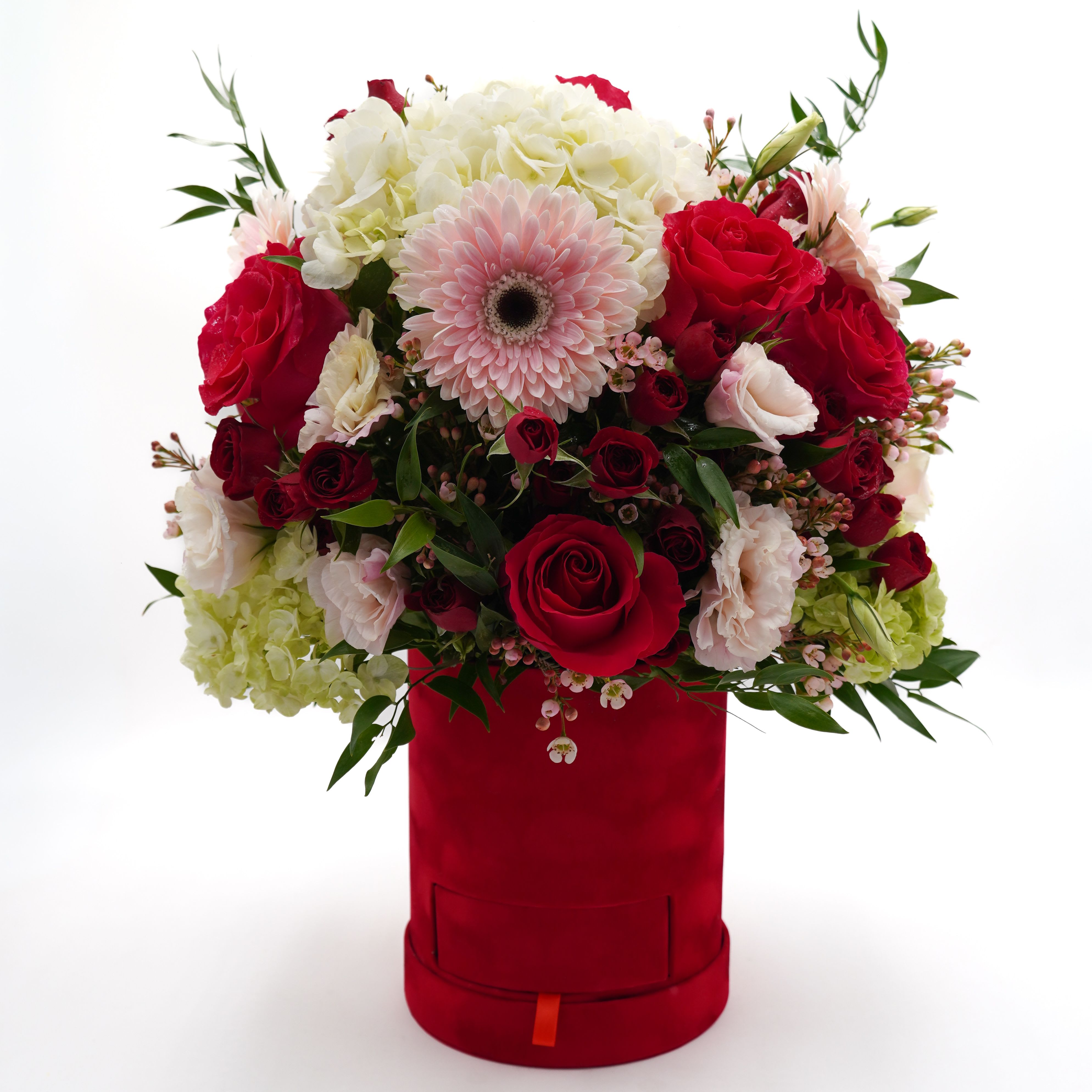 Red and white mixed bouquet in a red hatbox