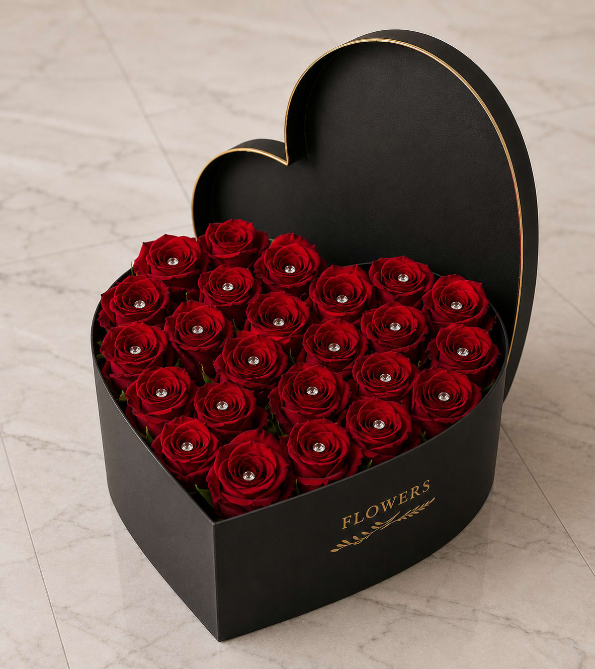 Luxury in Bloom - Tightly clustered, velvety red roses set inside a matte black heart-shaped box with gold trim make an unforgettable anniversary or Valentine's Day bouquet. The dramatic red-and-black contrast reads as timeless romance - the kind of arrangement that makes the person you're thinking of feel truly cherished the moment they see it.  Each rose is finished with a small silver jeweled accent at the center, giving the display a polished, gift-like sparkle against deep petals. The presentation box is heart-shaped with subtle gold lettering and trim, lending a luxe, keepsake quality that elevates the roses from casual flowers to a statement gift.  Perfect for anniversaries, romantic milestones, or any moment when you want to say "I adore you," this arrangement arrives fully arranged and ready to present. Its compact, boxed format makes it easy to display on a bedside table or mantel; light misting keeps the roses fresh for several days while still looking exquisitely styled.