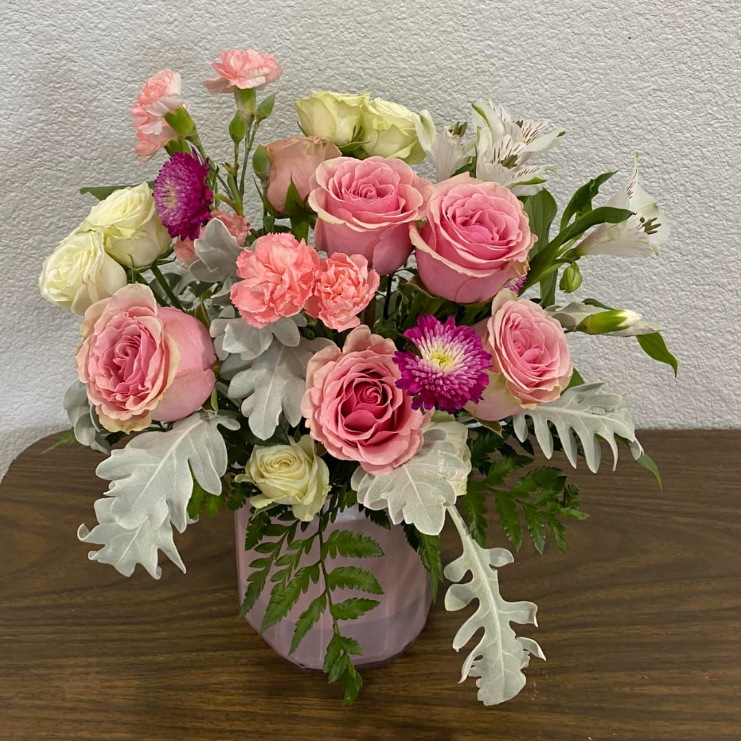 Pink and white rose arrangement in a pink vase