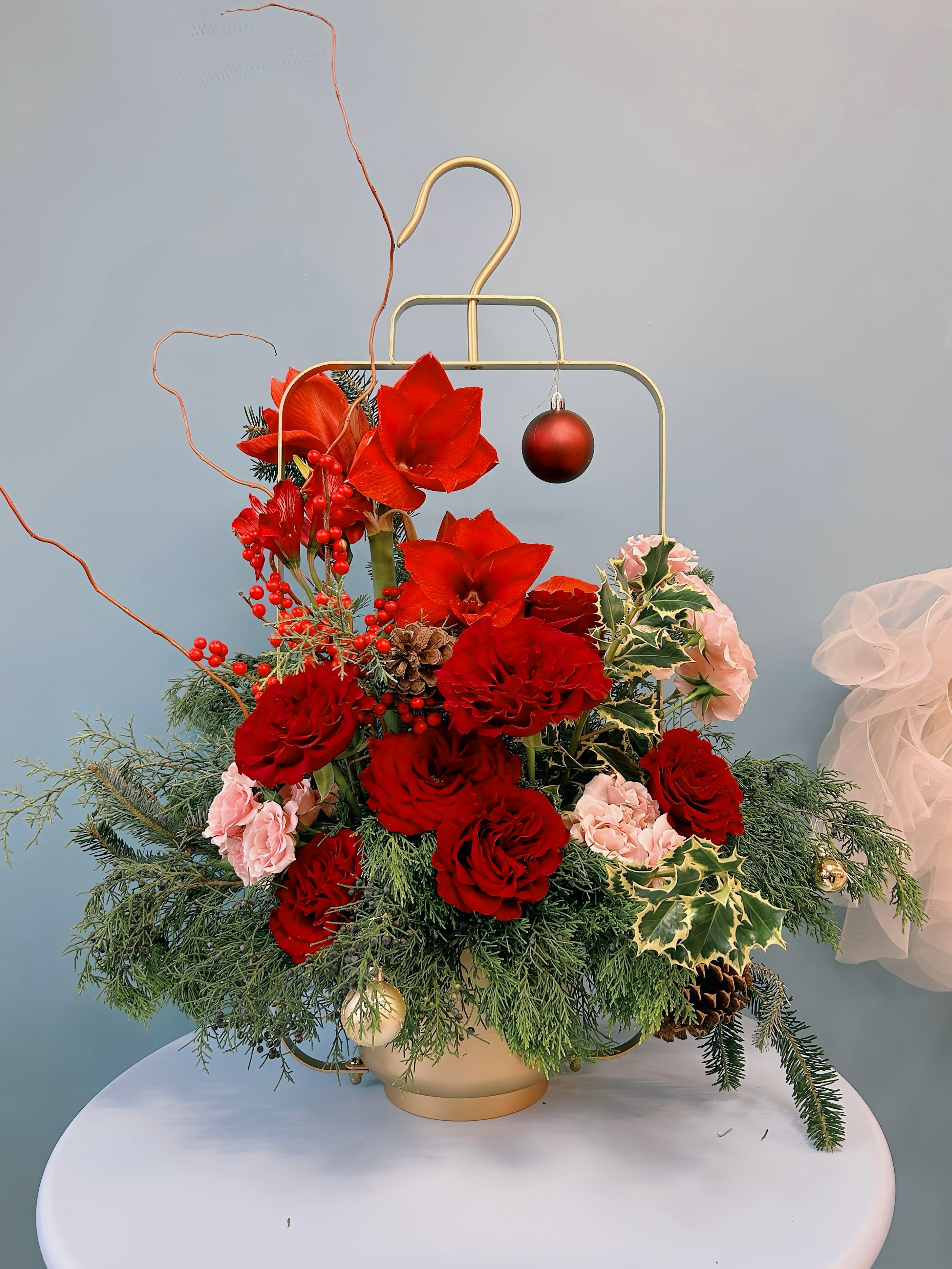 Velvety Elengance Grand Entry - Elevate your holiday décor with this exquisite entryway arrangement, a masterpiece from our Velvet Noel Collection. Showcasing opulent Christmas Amaryllis, lush Rose Heart and Rose Angelica blooms,  this design is complemented by a textured symphony of Carolina Sapphire, Cypress, and Blue Spruce. Every detail has been meticulously curated to exude timeless elegance and refined charm.  Perfect for gracing your entryway or any prominent space, this luxurious centerpiece creates a warm and inviting atmosphere, embodying the sophistication and splendor of the holiday season.