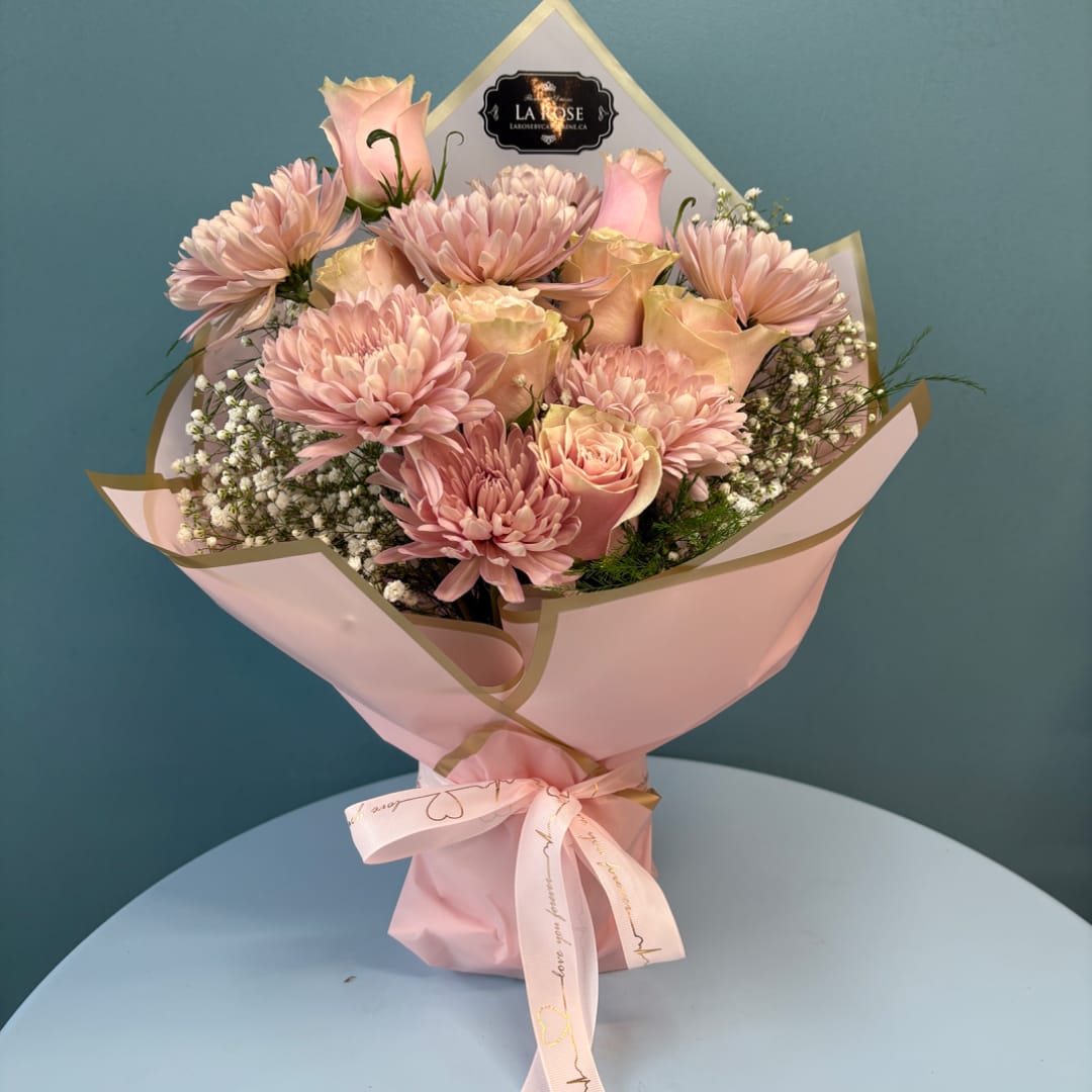 Pink roses and chrysanthemums in a wrapped bouquet with a ribbon