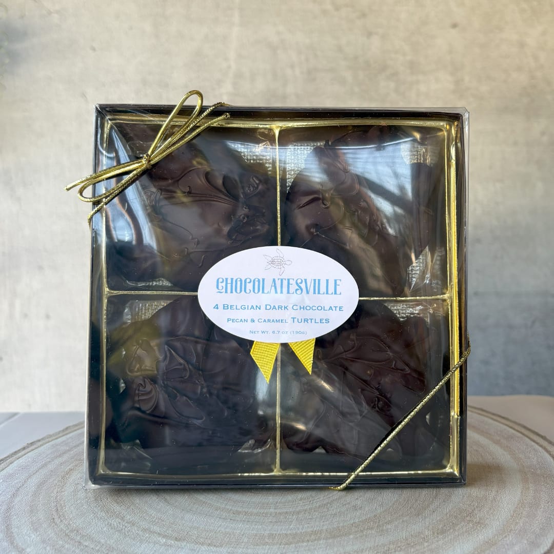 Box of dark chocolate turtles tied with a gold ribbon