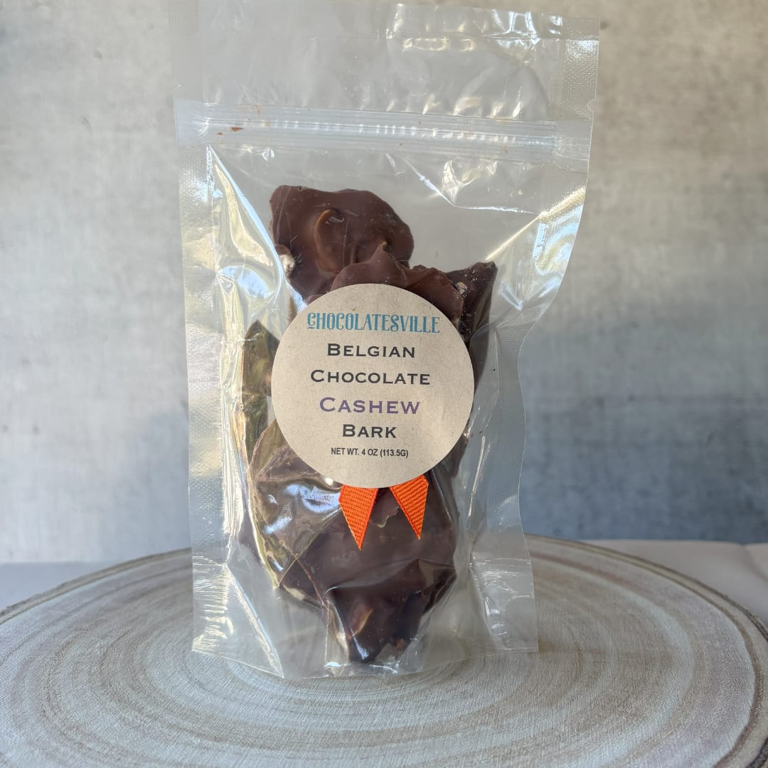 Bag of Belgian chocolate cashew bark with a label and orange ribbon