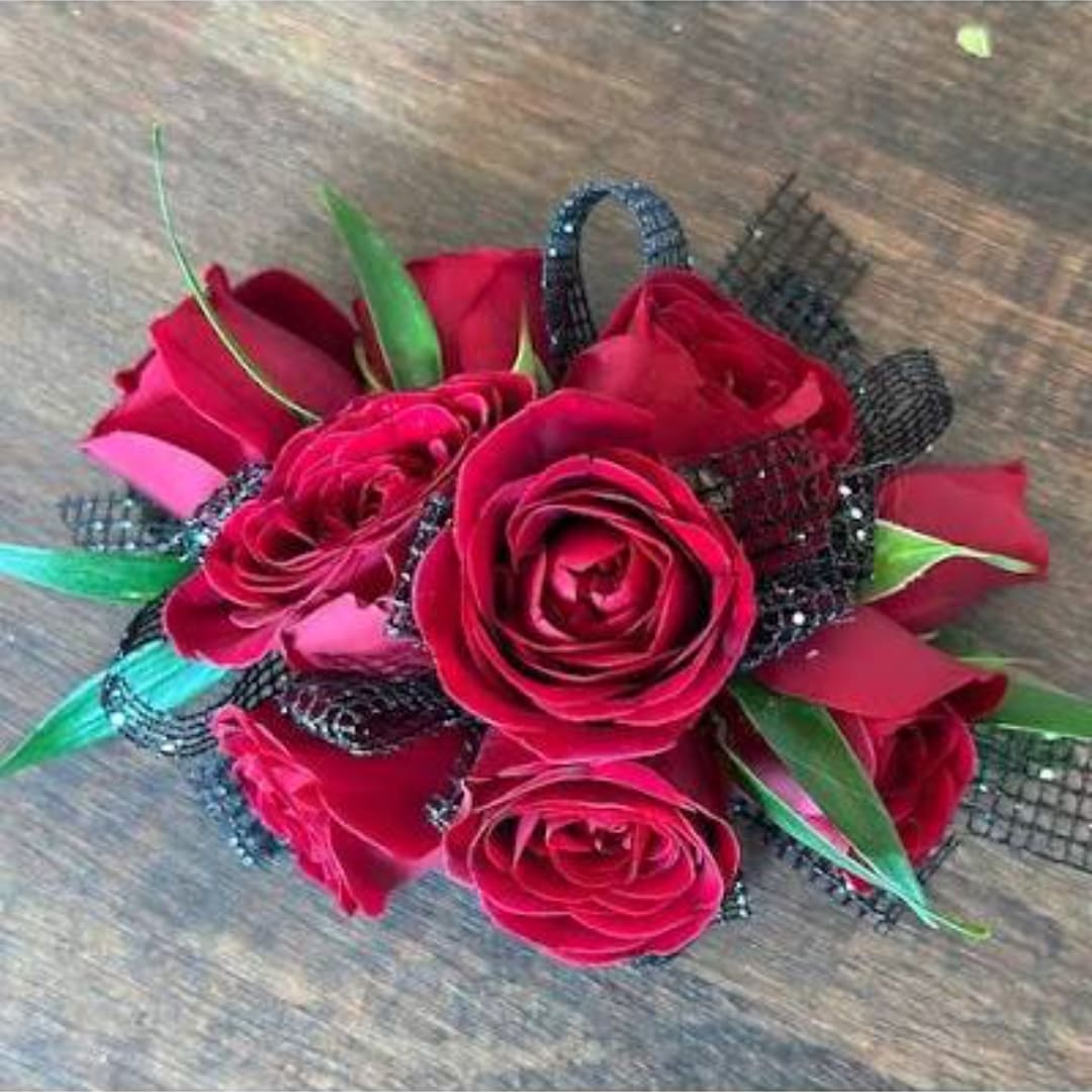 Red rose bouquet with black ribbon accents on a wooden surface