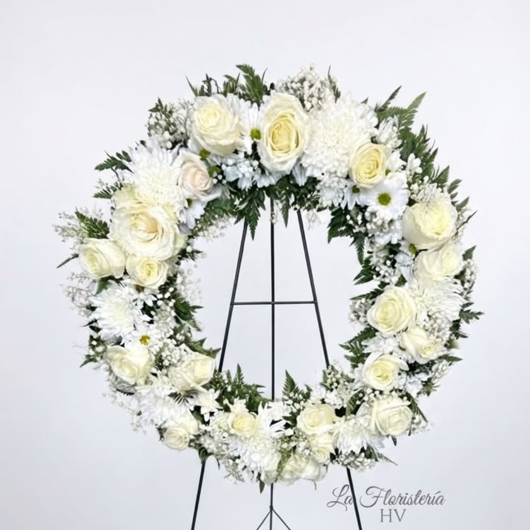 White floral wreath on a black stand
