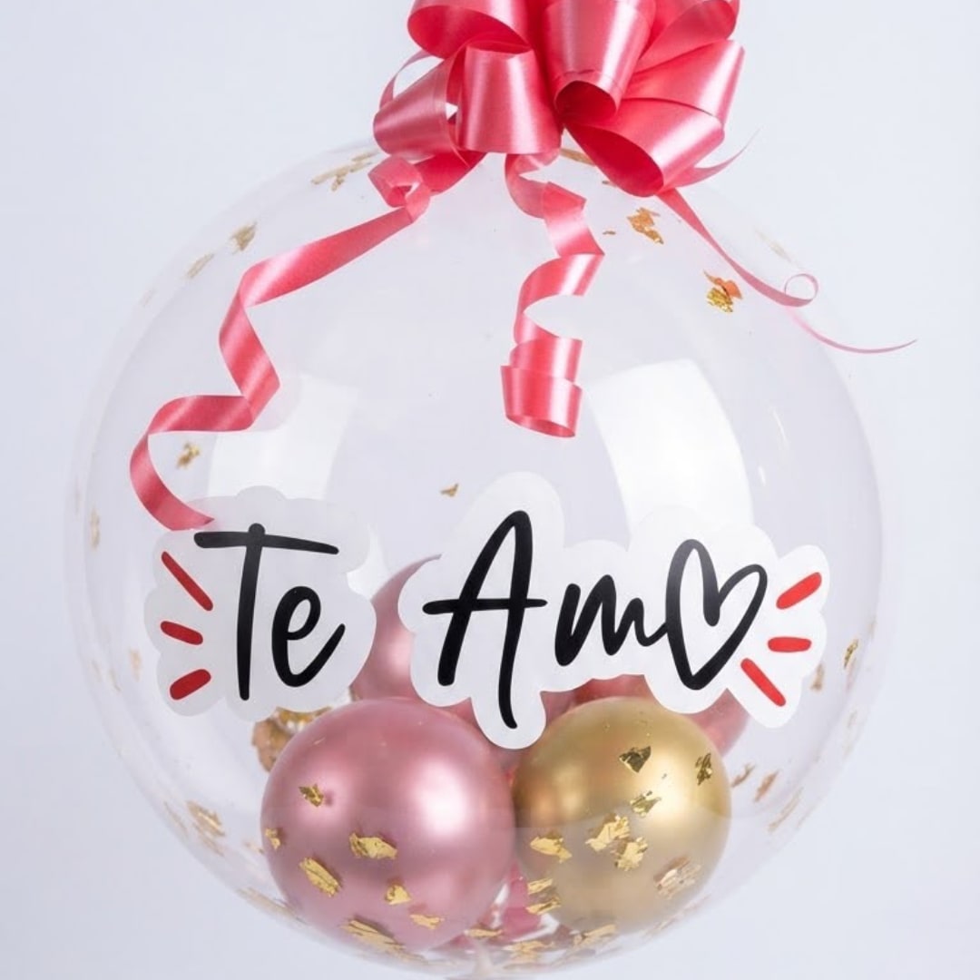 Clear balloon with pink ribbon, gold confetti, and "Te Amo" text