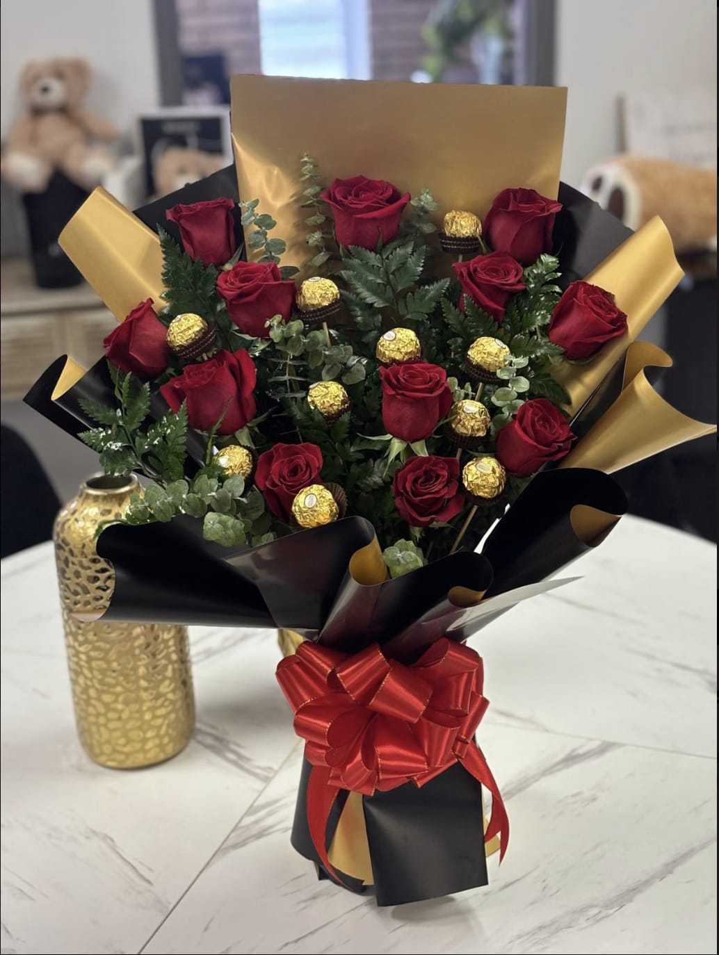 Chocolately Rose - Red rose arrangment with Ferrero Chocolates, a great combination of flowers and chocolates.  Includes: Red Roses, 10 Ferrero Chocolates, Spiral Eucalyptus, leather leaf wrapped in black and gold Korean waterproof paper.