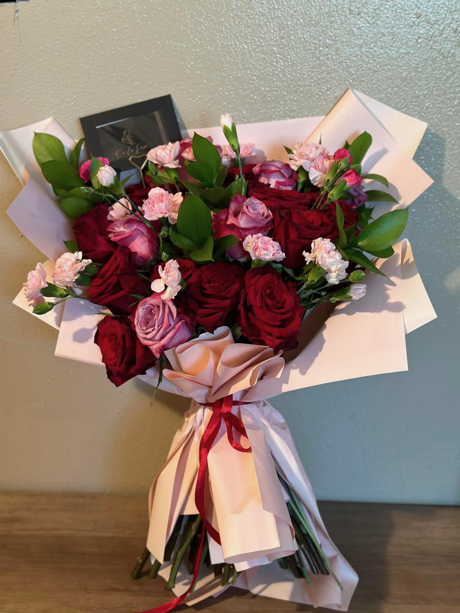 Sweet Love - A passionate bouquet of pink roses and red roses to represent a sweet love.  Includes: pink and red roses, mini carnations, and ruscus wrapped in Korean waterproof paper.
