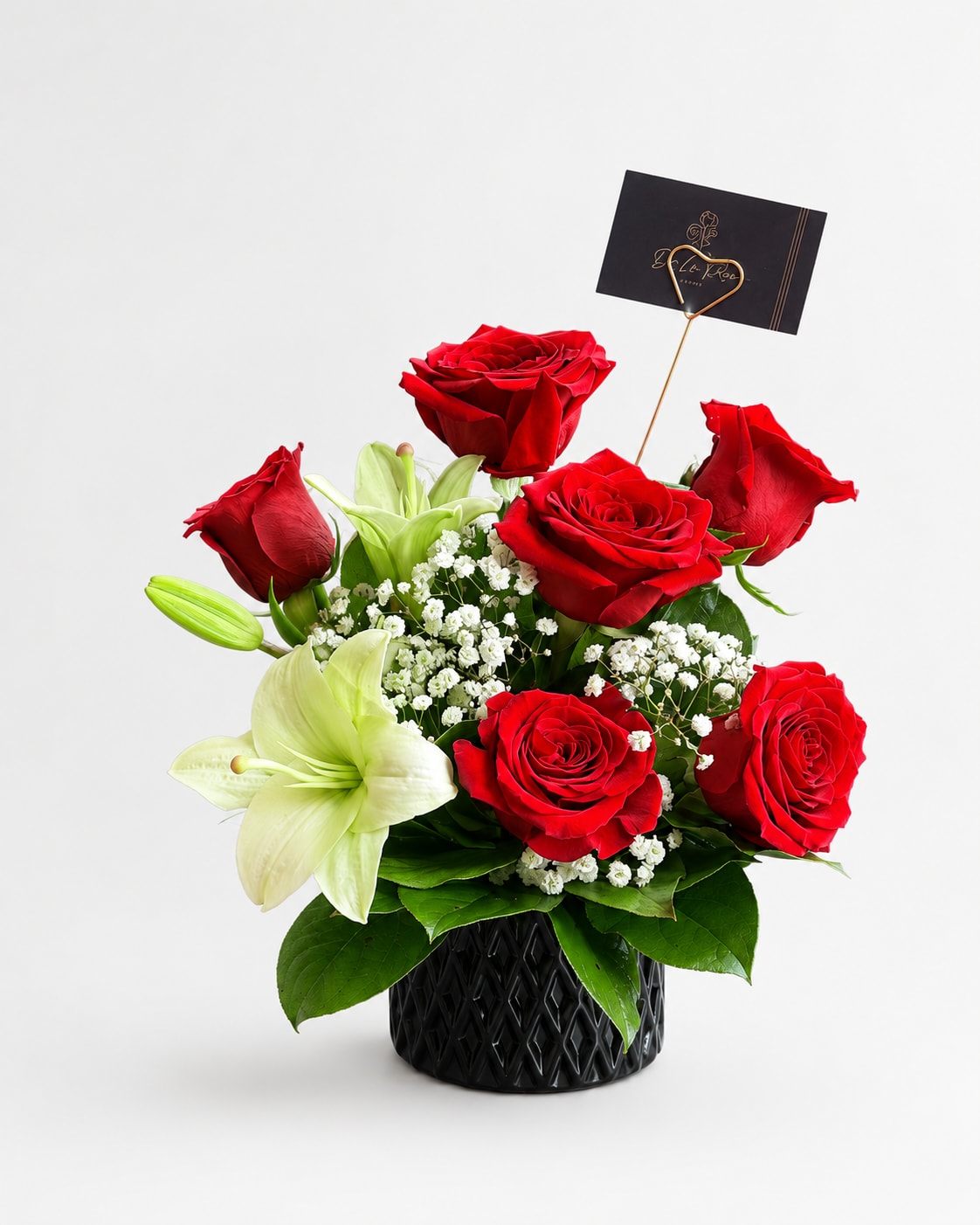 Red roses and white lilies arranged in a black vase