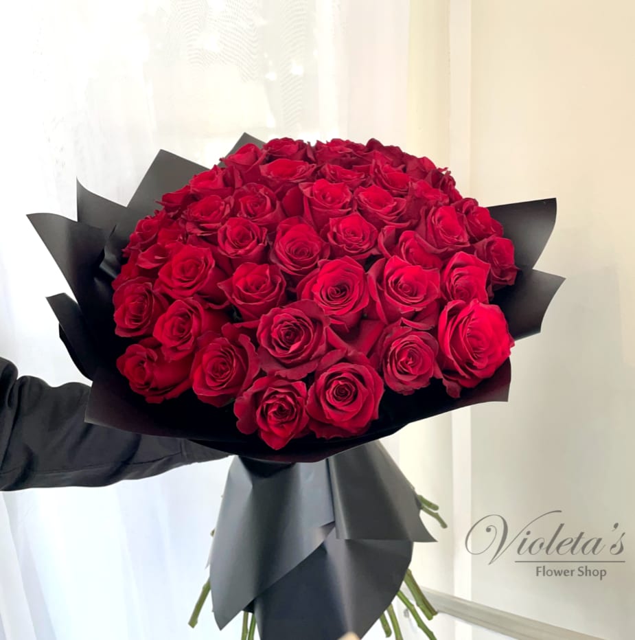 Large bouquet of red roses wrapped in black paper
