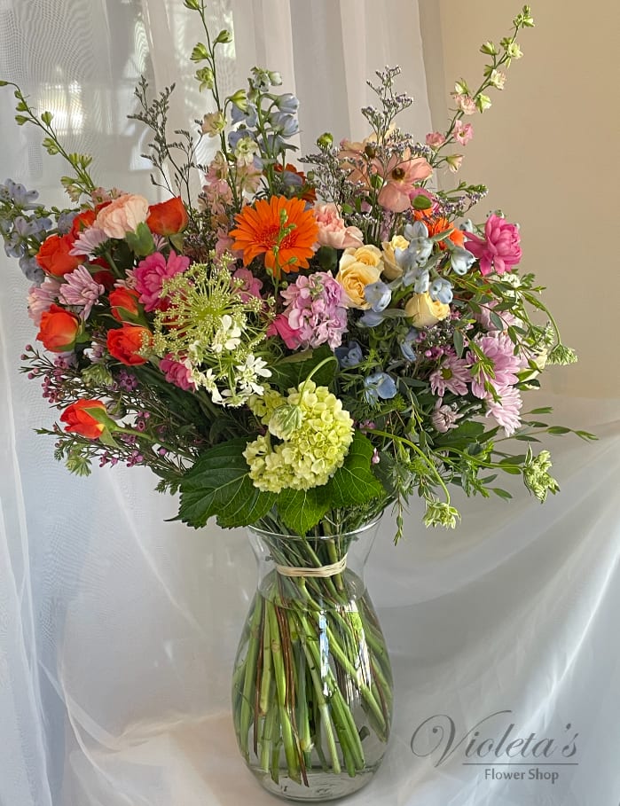 Colorful mixed bouquet in a clear glass vase with tall stems