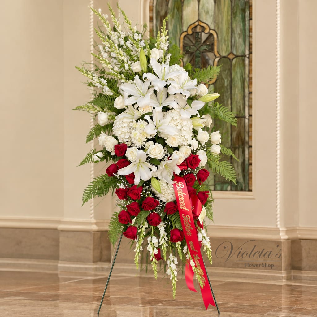 Tall standing spray of white lilies and red roses on an easel