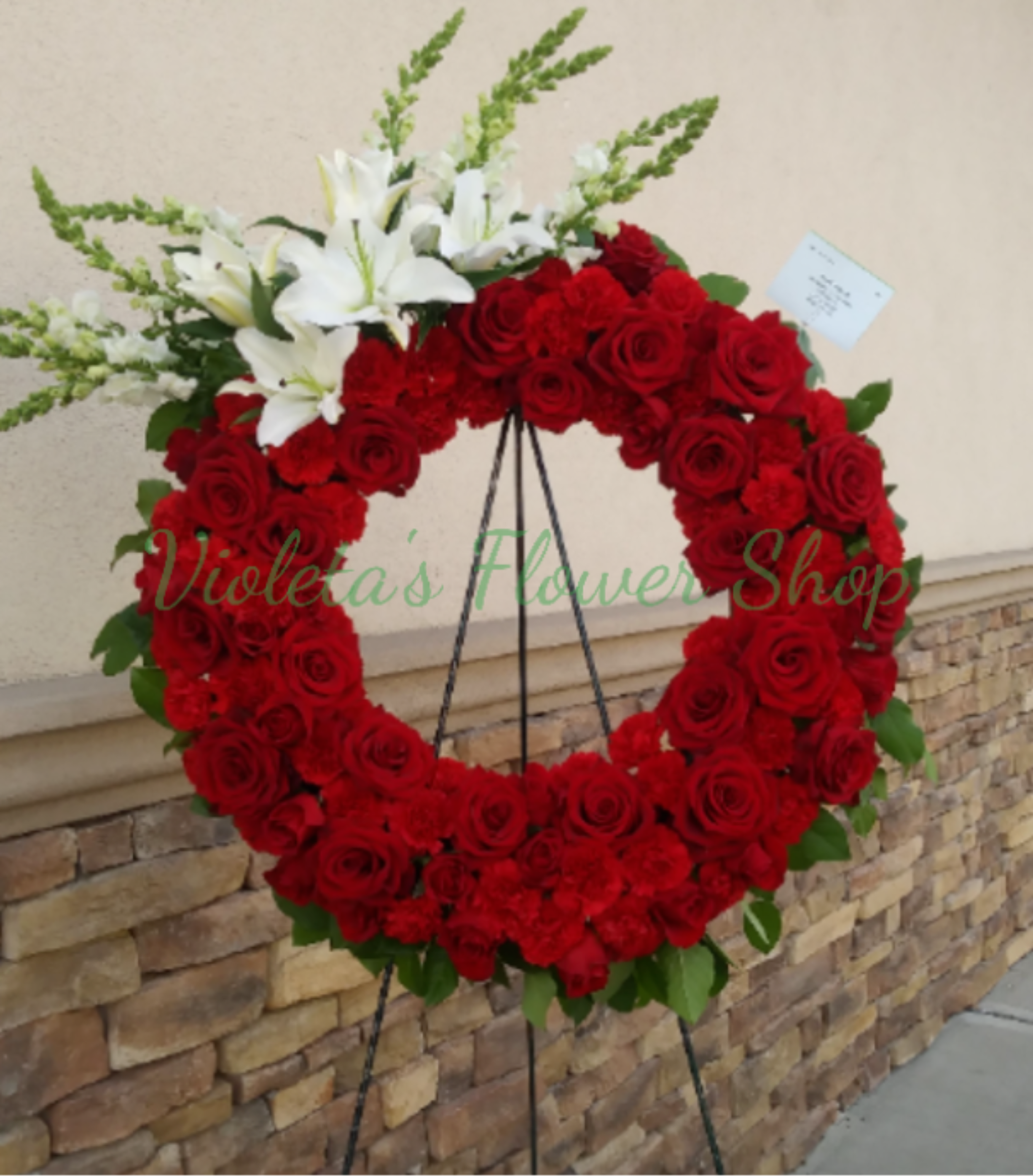 Red rose wreath with white lilies on a standing easel