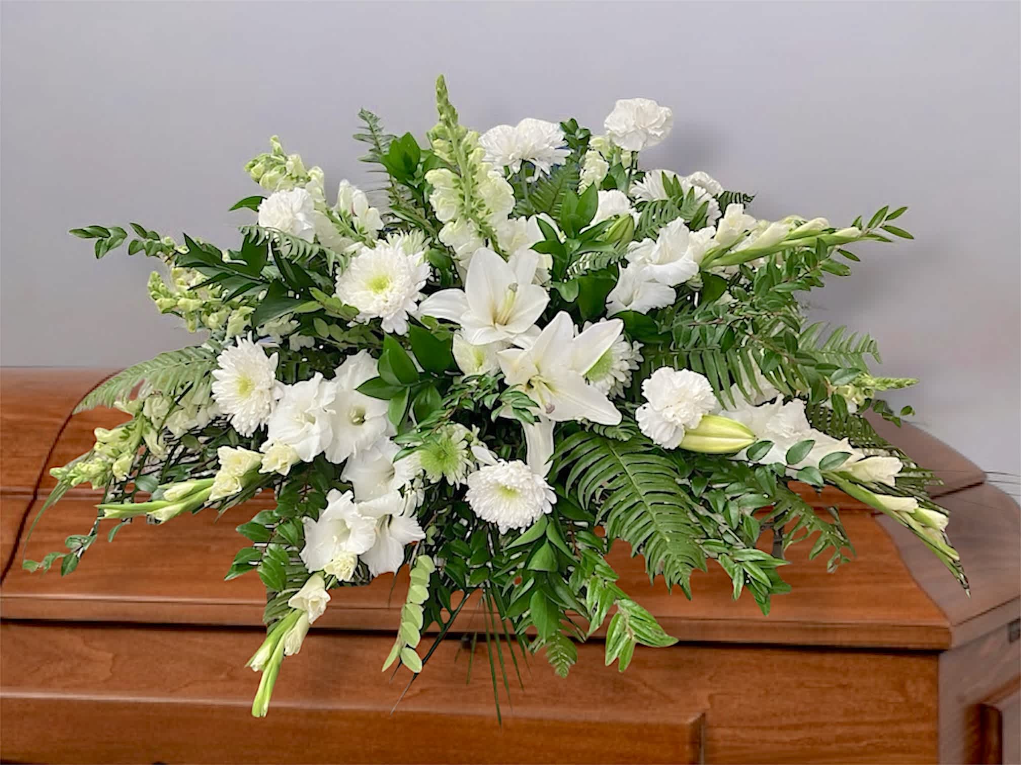 White floral spray on a wooden casket