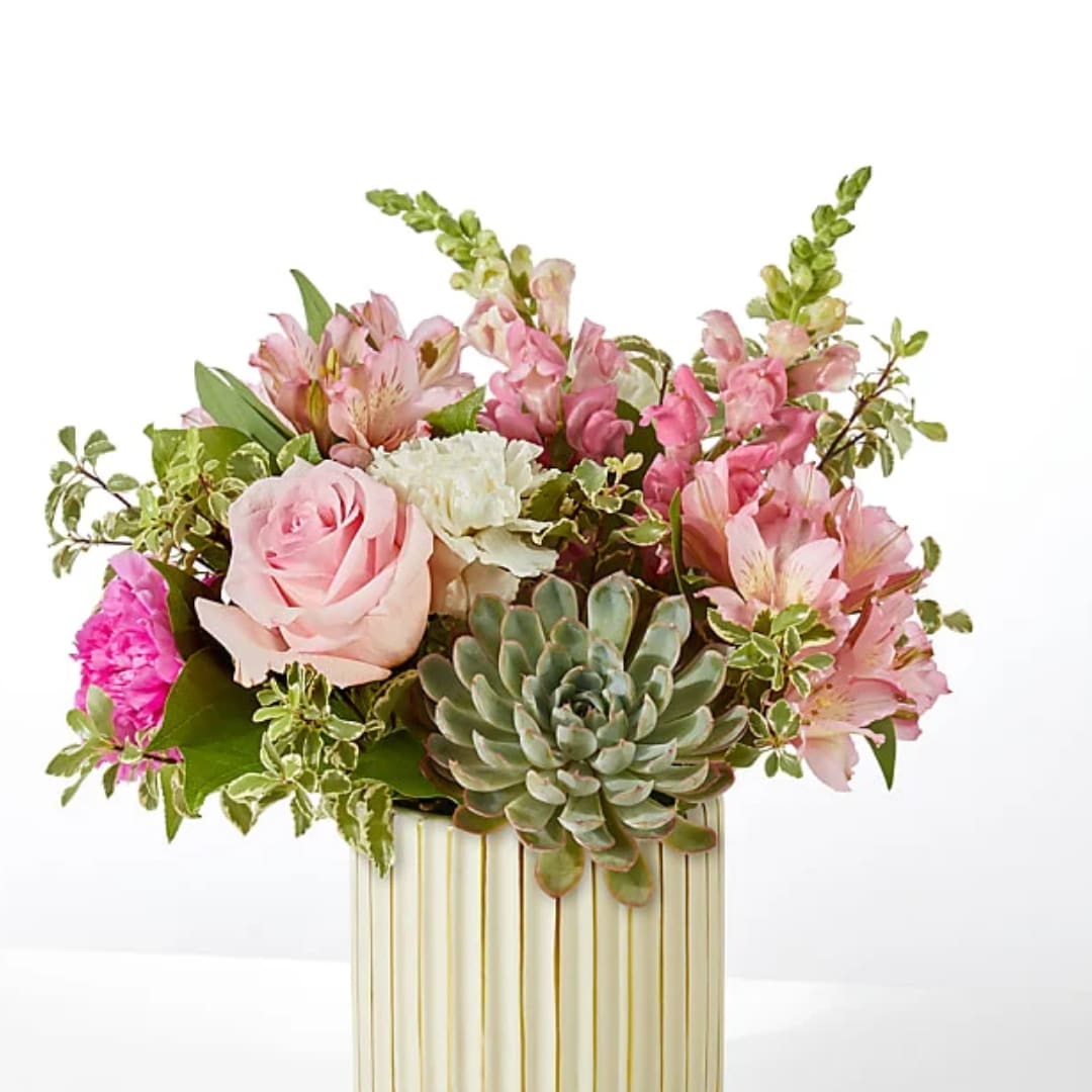 Pink and white floral arrangement with a succulent in a striped vase