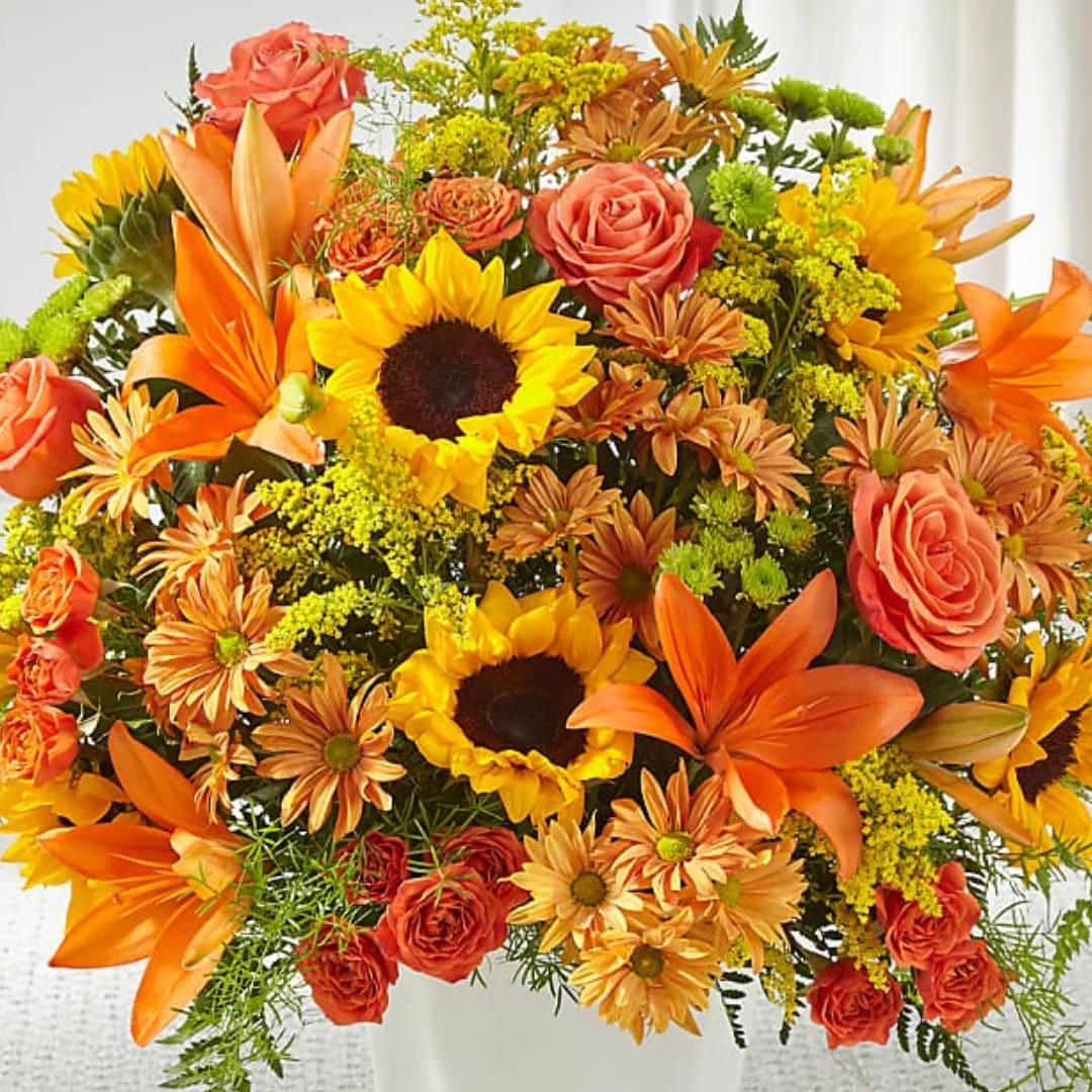 Bright bouquet of sunflowers, orange lilies, and coral roses