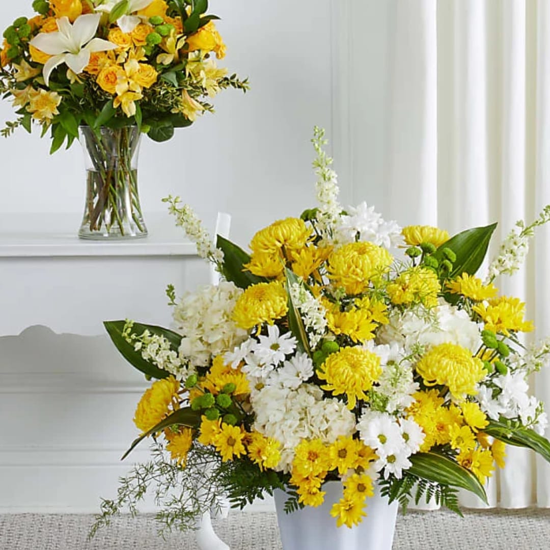 Yellow and white flower arrangements in glass and white vases