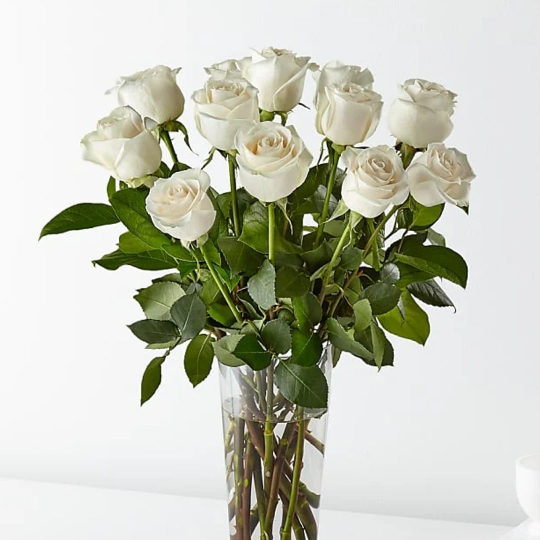 White roses arranged in a clear glass vase
