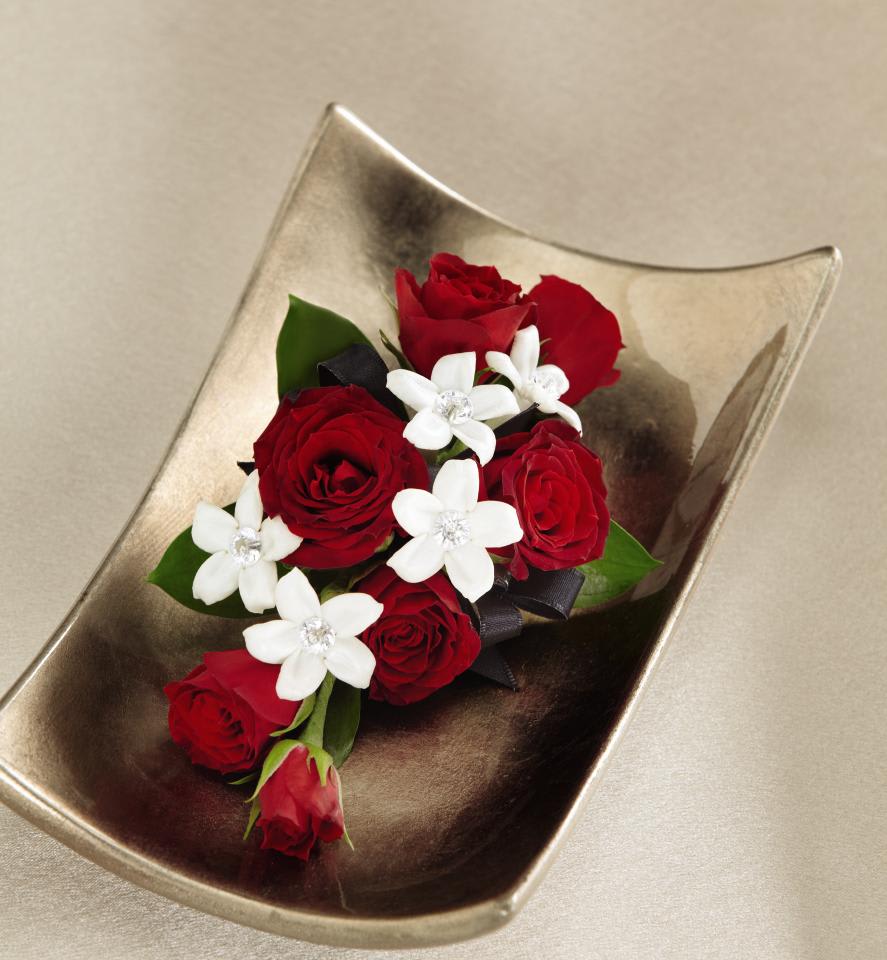 FTD Poetry Corsage - The FTDÂ® Poetryâ¢ Corsage is the perfect way to complement the wonderful   women in your life on your wedding day. Brilliant red spray roses are   gorgeously accented with white stephanotis blooms donning sparkling pins   at the center to create an eye-catching display of floral beauty and   elegance. Approx. 4âH x 3âW.   