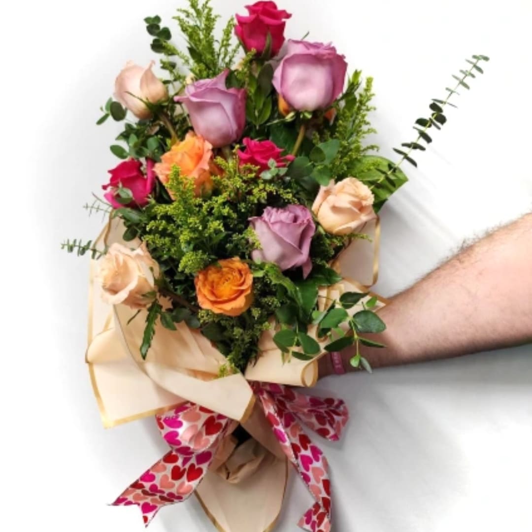 Handheld bouquet of multicolored roses with a heart-patterned ribbon