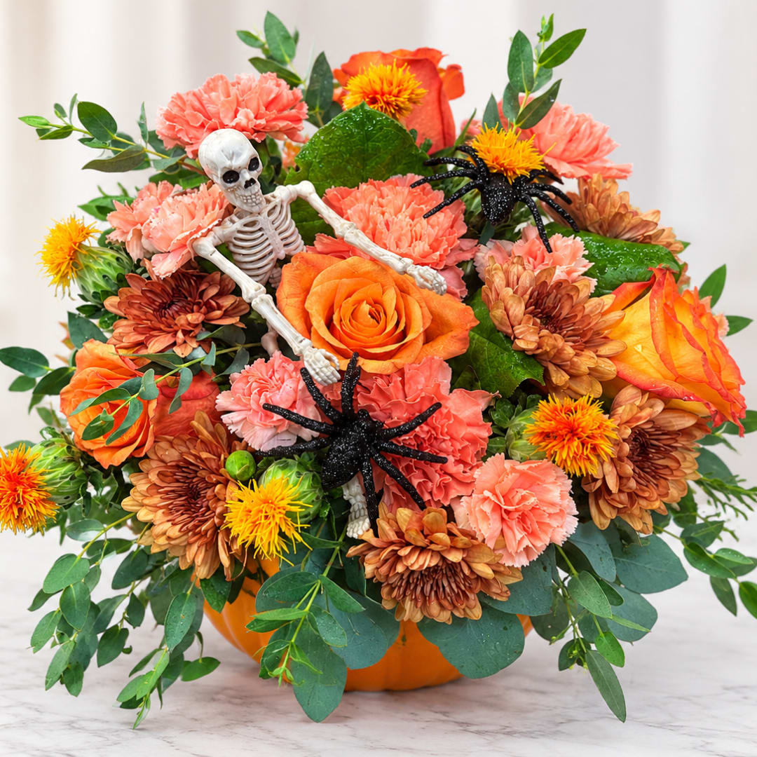 Halloween bouquet with a skeleton, spiders, and orange flowers in a pumpkin container