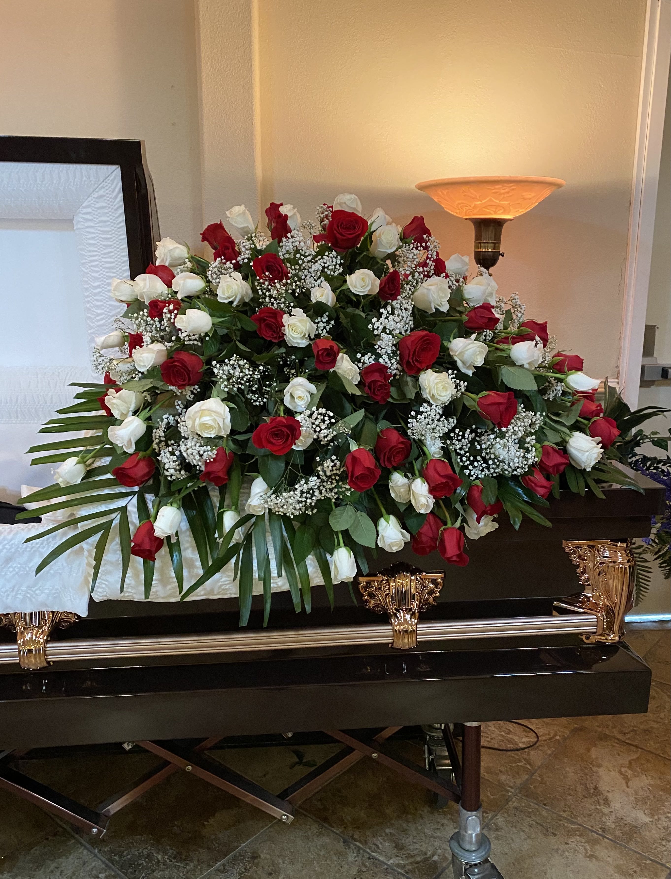 Sympathy Rose Casket Spray  - A classic sympathy casket spray featuring fresh Roses accented with greenery.  If you would like one of the available colors below, please specify your preference in the Special Instructions section when placing your order, if not then the order will be made with red roses. Color requests are subject to availability.  Available Colors:  1)Pink 2)Yellow 3)Off-White 4)Fuchsia 5)Lavander