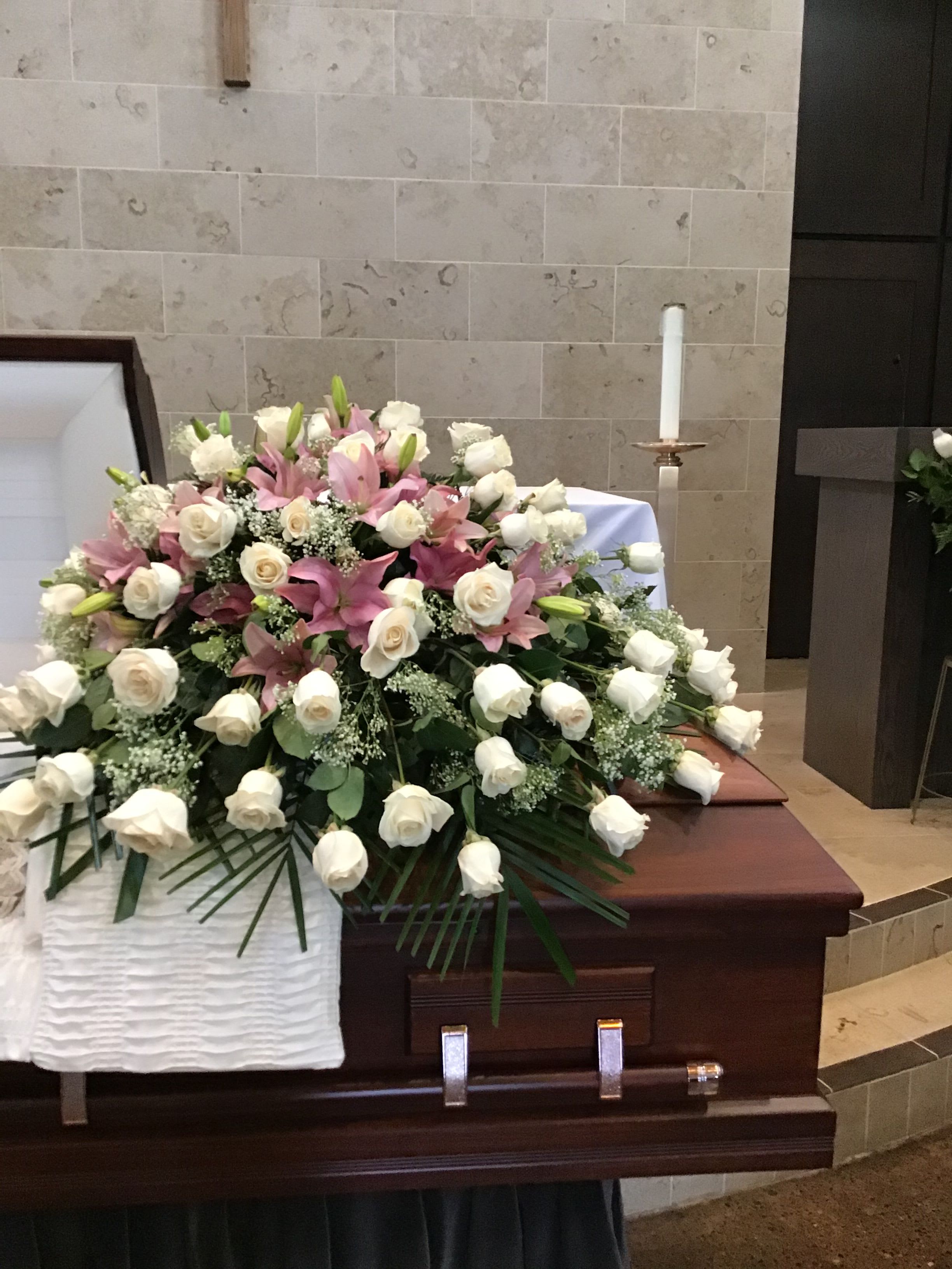 Sympathy Casket Spray Roses &amp; Lilies - Beautiful Casket Spray made with Roses, Lilies, and accompanied by greenery.  If you would like one of the available colors below for the roses, please specify your preference in the Special Instructions section when placing your order, if not then the order will be made with red roses. Color requests are subject to availability.  Available Colors:  1)Pink 2)Yellow 3)Red 4)Fuchsia
