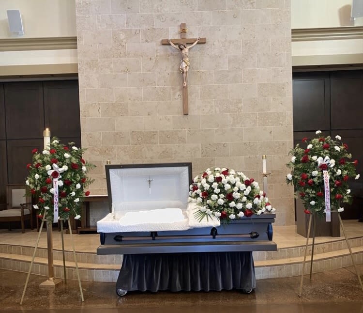 Crimson Remembrance Collection - Celebrate a cherished life with a beautifully coordinated floral tribute designed to honor lasting memories. This collection includes an elegant casket spray accompanied by two matching standing sprays, creating a balanced and meaningful display throughout the service. Rich red and pure white blooms come together to symbolize love, respect, and a life that will never be forgotten.  What's included: 2 standing easels and 1 casket spray.