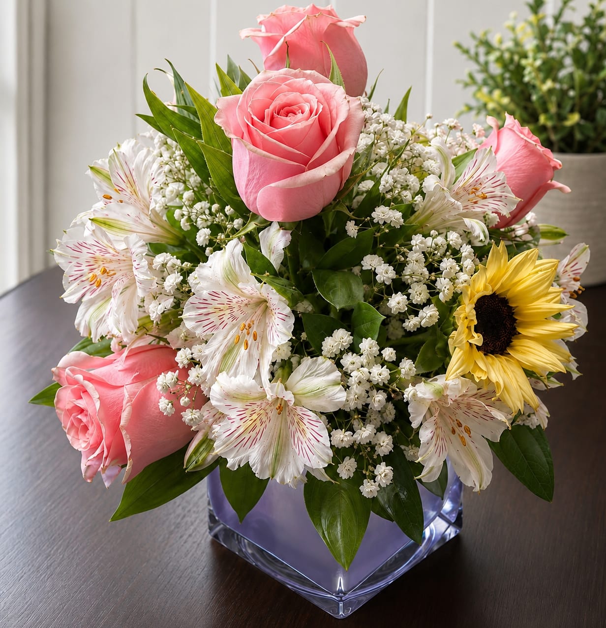 Pink roses and white alstroemeria in a square glass vase