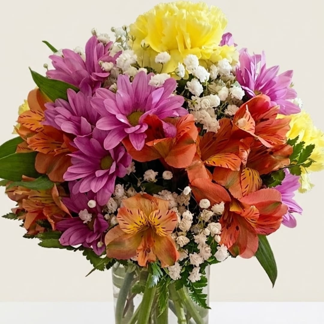 Colorful bouquet of daisies and alstroemeria in a glass vase