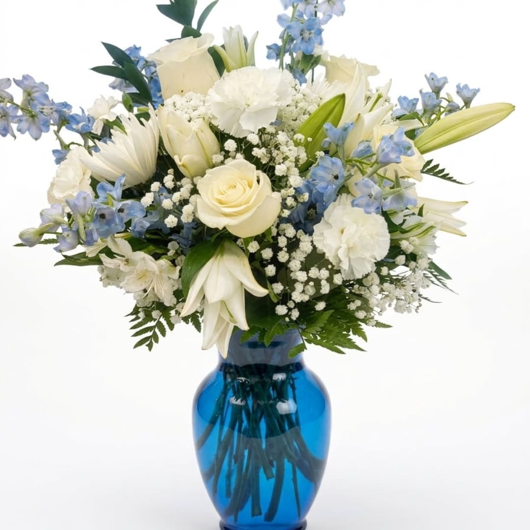 White and blue mixed bouquet in a blue glass vase