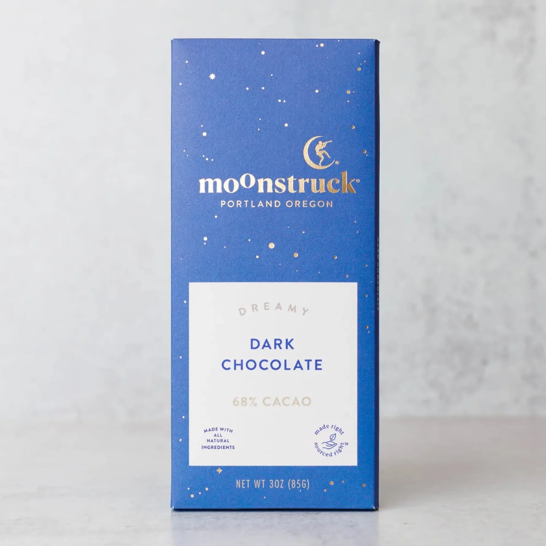 Blue box of Moonstruck dark chocolate on a light surface.