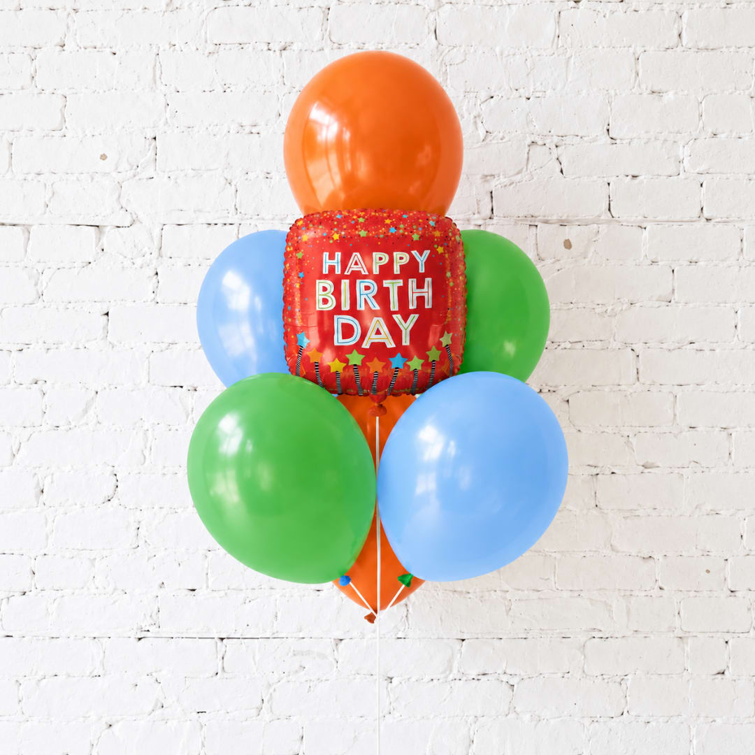 Birthday balloon cluster with a red "Happy Birthday" balloon and colorful round balloons