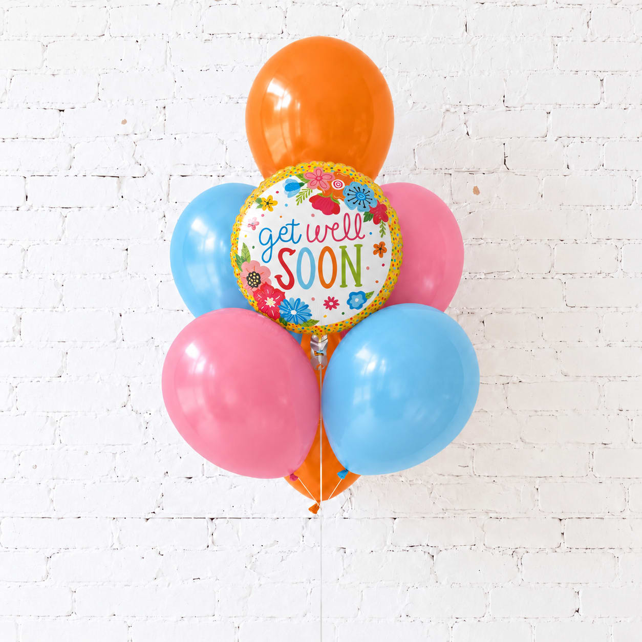 Cluster of colorful balloons with a "get well soon" balloon in front