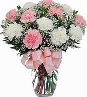 Pink and white carnation arrangement with baby’s breath in a clear vase with a pink bow