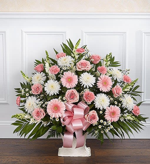 Fan-shaped pink and white arrangement with roses and daisies in a white container with a pink bow