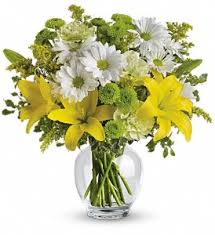 Round glass vase with yellow lilies, white daisies, and green button flowers
