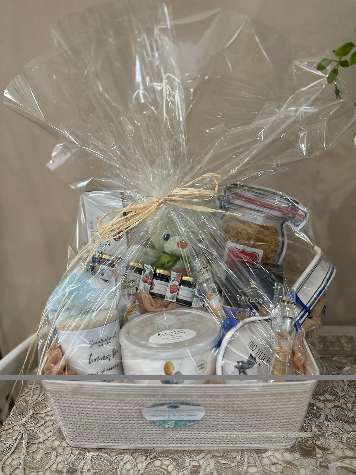 Ratatouille Be Well Basket - Our "bee well" gift basket contains a honey tea candle made of bee's wax and coconut, a ratatouille soup bowl and spoon rest, soup mix, betown honey spoons, Taylor's Earl Grey tea, crackers, a teddy bear, hand towel, and an assortment of preserves.