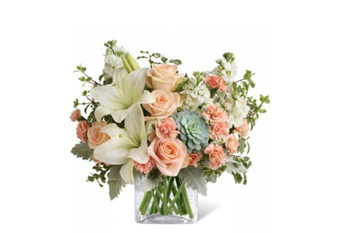 Bouquet of peach roses and white lilies in a clear glass vase
