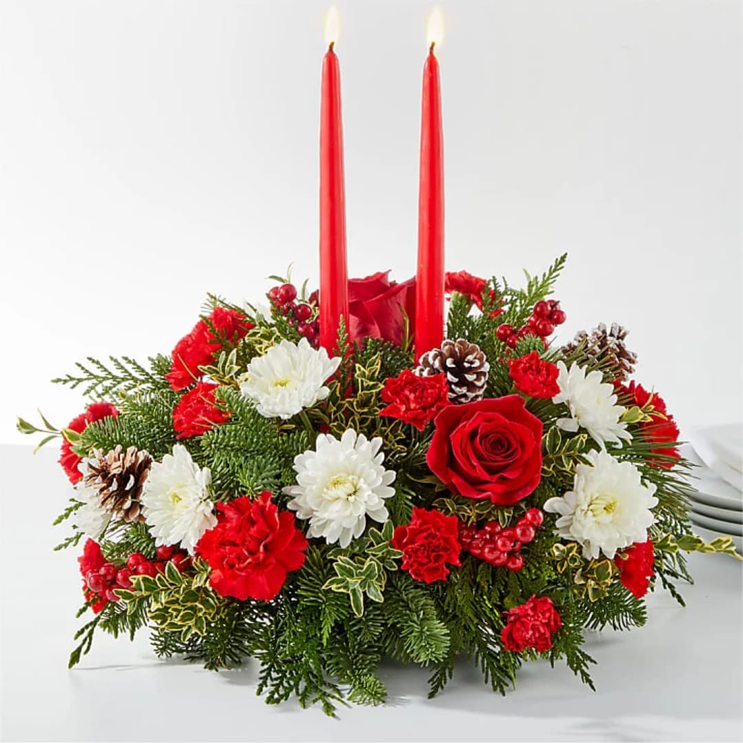 Red candle centerpiece with white and red flowers and pinecones