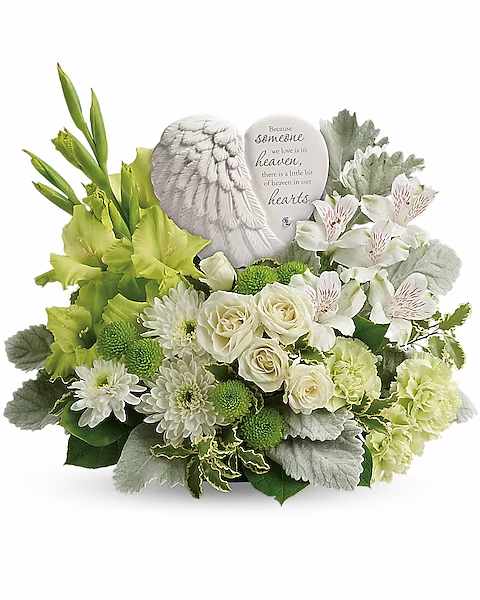 White and green sympathy arrangement with roses and daisies around a memorial plaque