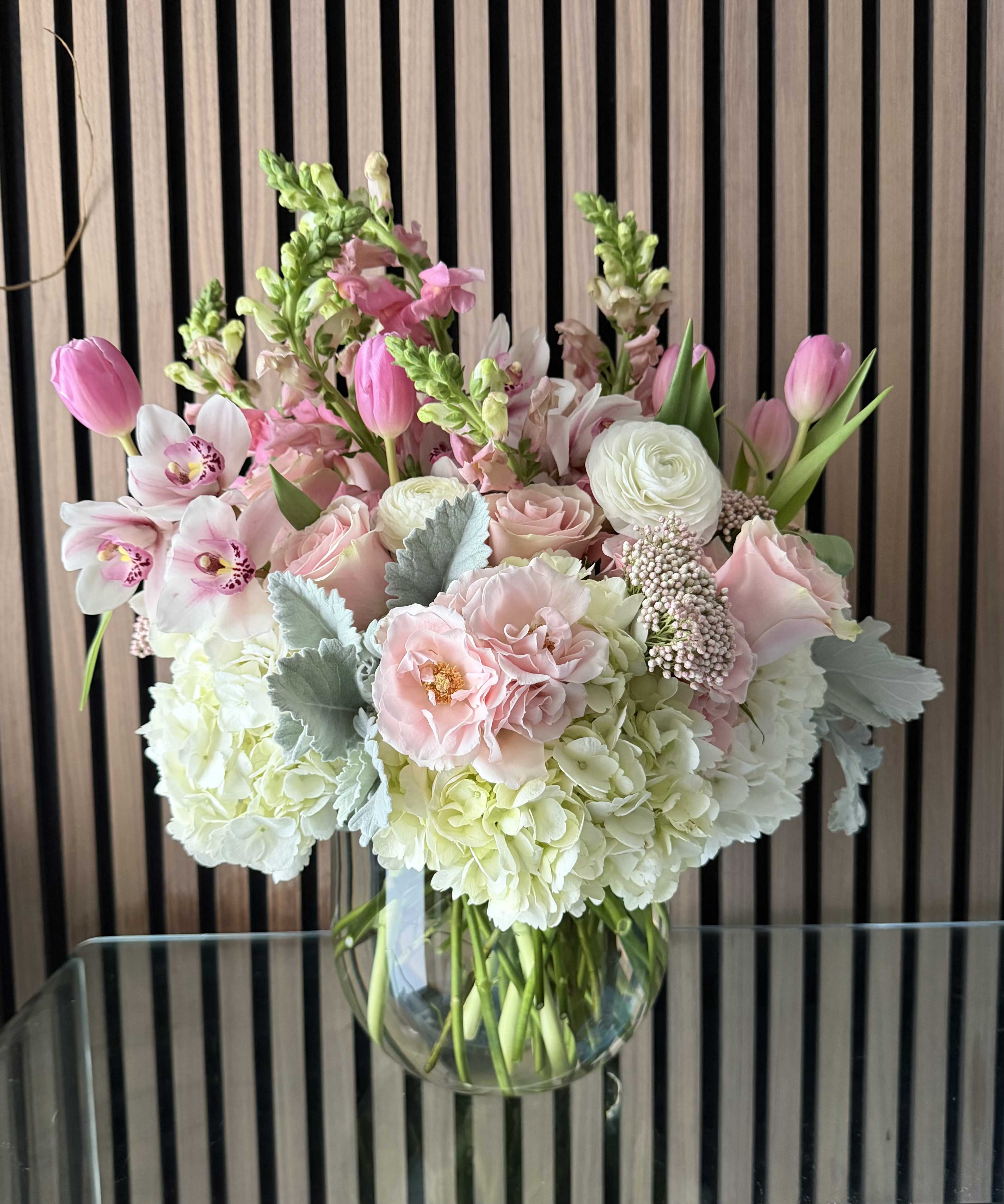 Blooming Grace - Soft pink tulips, blush roses, white hydrangeas and pale orchids in a clear glass vase-romantic, springlike mix with green accents, perfect for birthdays or thoughtful everyday gifting.