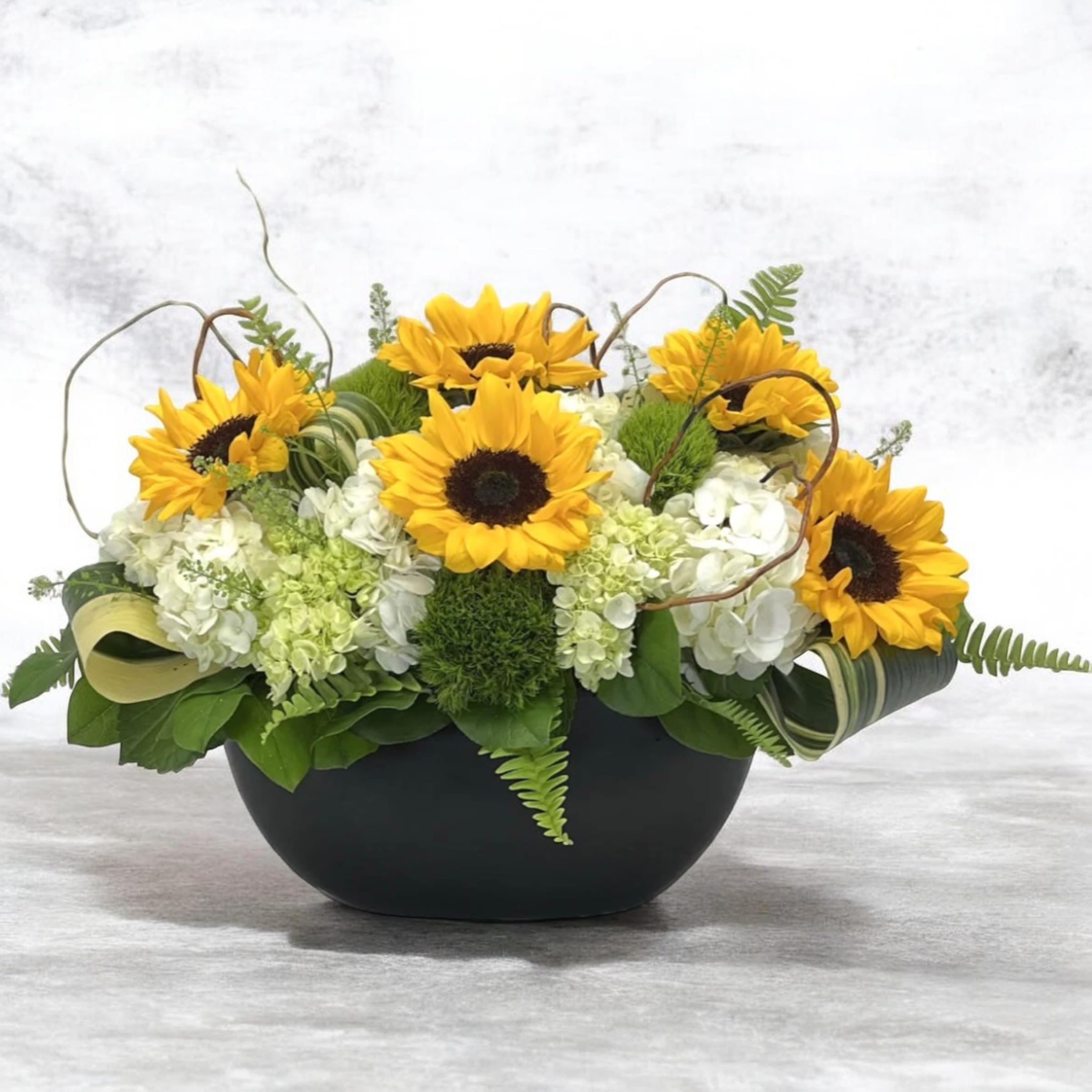 Sunflowers Garden  - Bright yellow sunflowers with white hydrangeas and green accents in a matte black bowl-cheerful, bold, and perfect for everyday gifting or celebrations.
