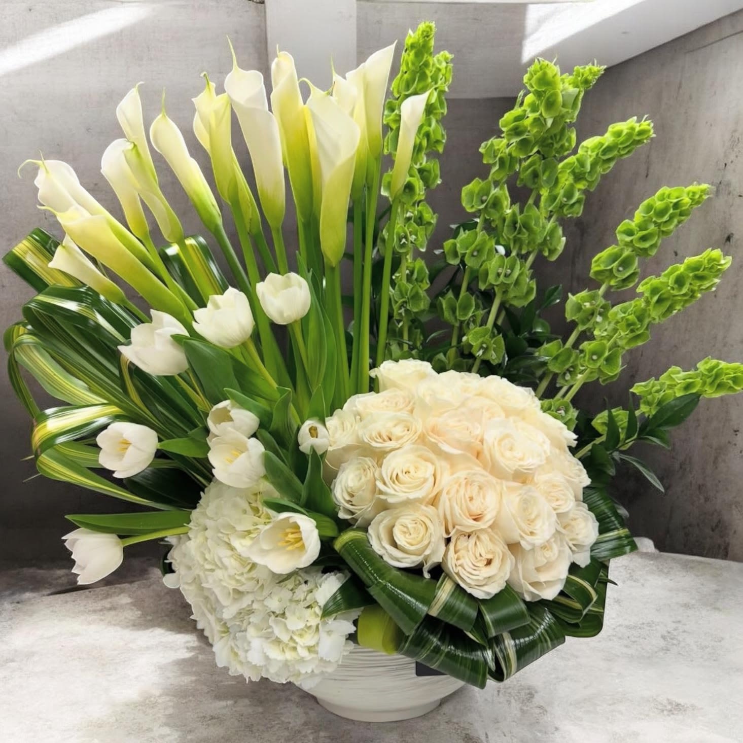 Serenity - White and green arrangement of roses, calla lilies, tulips, hydrangea and snapdragons in a white ceramic vase - elegant, sculptural and serene for weddings or sympathy.