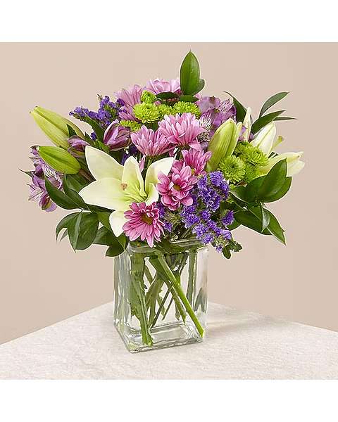 Mixed pink and purple flowers in a clear glass vase