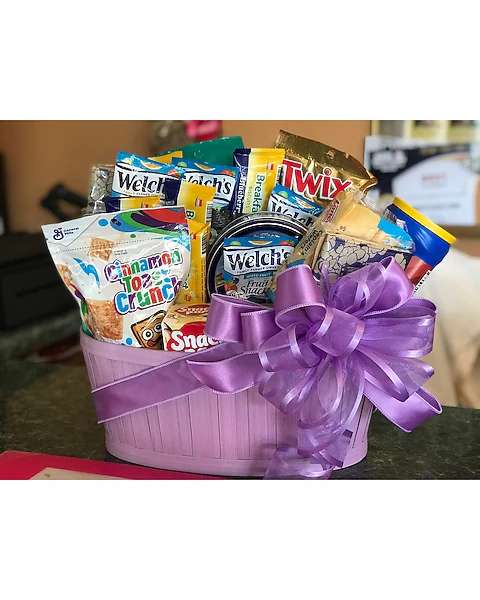 Purple gift basket filled with assorted snack packs and tied with a ribbon