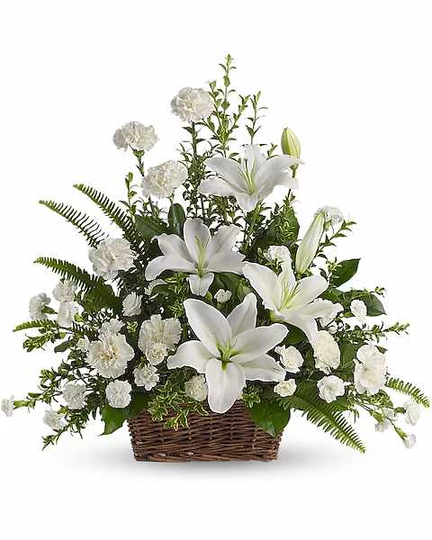 White lilies and carnations arranged in a wicker basket