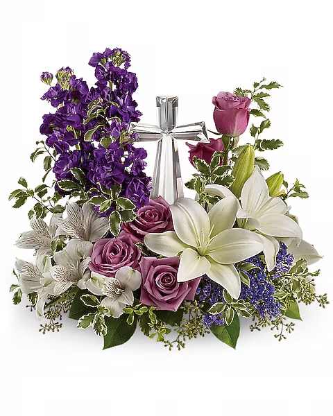 Purple and white floral arrangement with roses and lilies around a silver ribbon