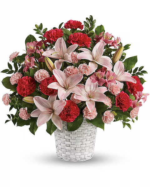 Pink lilies and carnations arranged in a white woven vase