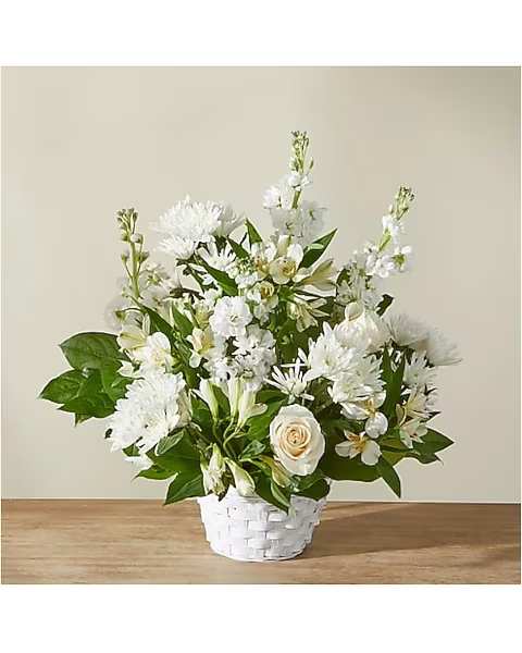White floral arrangement in a white basket vase
